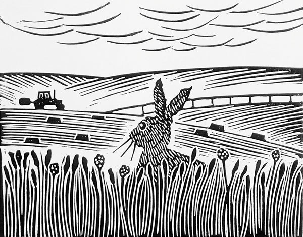 Lino print in black ink of hare gazing at tractor working in a field in the distance