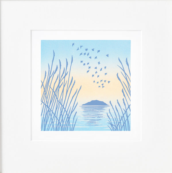 Mounted linocut of linnet birds flying over an island