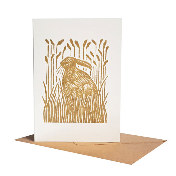 Hare sitting amongst grasses printed with light gold ink. Suitable as a notecard or greeting card. 