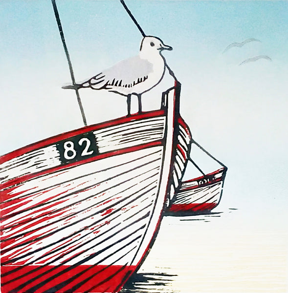 Linocut in red, blue and black ink of seagull perched on beached boat