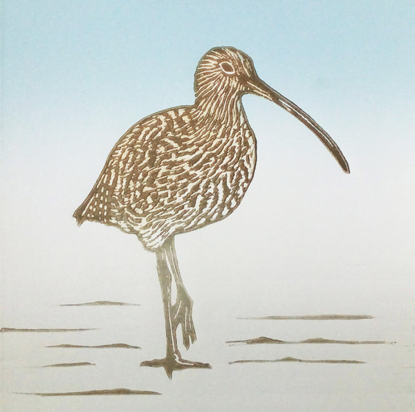 Linocut of curlew standing poised on the shore