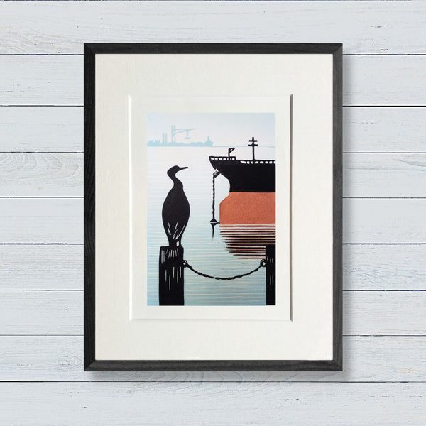Lino print in black, blue and orange ink of oil tanker at port and cormorant looking on