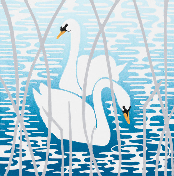 Mounted linocut of two white swans that glide upon water printed with blue ink tones